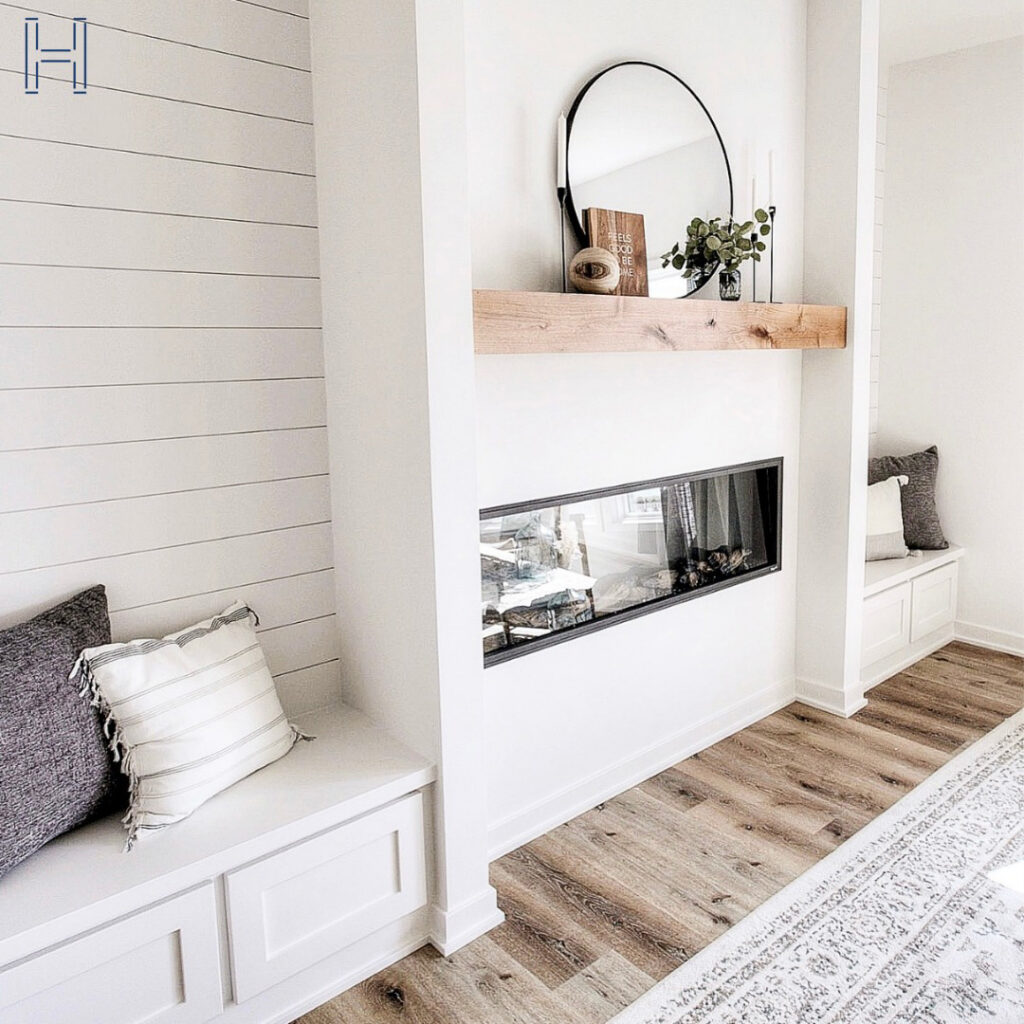 two seat storage that flank a center console with a fireplace and a shelf above to showcase finished basement storage ideas